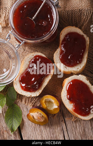 Sandwiches mit Pflaumen Marmelade close-up auf dem Tisch. Vertikale Ansicht von oben, rustikal Stockfoto