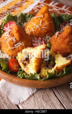 Arancini Reisbällchen mit Fleisch und Erbsen Nahaufnahme auf einer Platte. vertikale Stockfoto