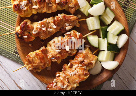 Chicken Satay bestreut mit Erdnüssen Nahaufnahme auf einer Platte. horizontale Ansicht von oben Stockfoto