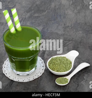 Weizen Grass Heide Drink mit Ergänzung Pulver in einer Porzellanschüssel und Löffel. Stockfoto