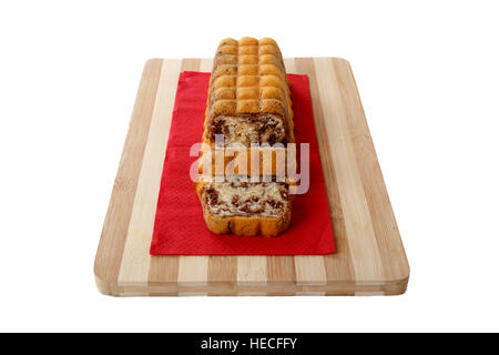 Schließen Sie detaillierte Vorderansicht des Baton Kakao Kuchen in Scheiben geschnitten auf ein Schneidebrett, isoliert auf weißem Hintergrund. Stockfoto