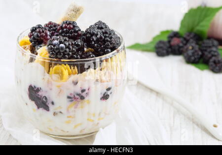 BlackBerry-Joghurt-Parfait in eine Glasschale auf einer weißen Tischdecke-Nahaufnahme Stockfoto