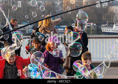 Busker unterhält Kinder mit Seifenblasen im Southbank Centre, London England Vereinigtes Königreich UK Stockfoto