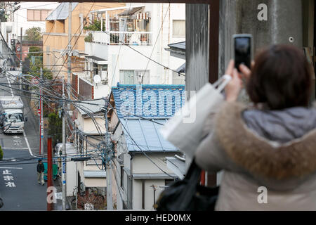 Eine Frau fotografiert die Treppe neben Suga-Schrein am 21. Dezember 2016, Tokio, Japan. Ausländische Besucher und Tokyoites sind die Treppe gekennzeichnet im Film Kimi No Na Wa (Ihr Name) zu einer touristischen Attraktion geworden. Der Film ist der dritte höchste Einspielergebnis japanische Film aller Zeiten und ist jetzt weltweit veröffentlicht wird. Nach einem 2. Dezember Release ist es bereits die höchsten Einspielergebnis japanische Film jemals in China und die vorgestellten Orte locken internationale Touristen. © Rodrigo Reyes Marin/AFLO/Alamy Live-Nachrichten Stockfoto