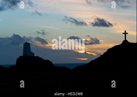 Newborough, Isle of Anglesey, Wales, UK. 21. Dezember 2016. Das Wetter.  St Dwynwens Cross und dem alten Leuchtturm sind am Abend der Wintersonnenwende der kürzeste Tag des Jahres 2016 gegen die untergehende Sonne auf Llanddwyn Island, aka Ynys Llanddwyn Silhouette. Das Wetter.  (Tageslicht) Daylength heute in London, UK werden 7 Stunden 49 Minuten 40 Sekunden. © Graham M. Lawrence/Alamy-Live-Nachrichten. Stockfoto