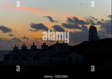 Newborough, Isle of Anglesey, Wales, UK. 21. Dezember 2016. Das Wetter.  Walisische Häuschen und dem alten Leuchtturm sind am Abend der Wintersonnenwende der kürzeste Tag des Jahres 2016 gegen die untergehende Sonne auf Llanddwyn Island, aka Ynys Llanddwyn Silhouette. Das Wetter.  (Tageslicht) Daylength heute in London, UK werden 7 Stunden 49 Minuten 40 Sekunden. © Graham M. Lawrence/Alamy-Live-Nachrichten. Stockfoto