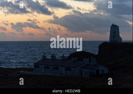 Newborough, Isle of Anglesey, Wales, UK. 21. Dezember 2016. Das Wetter.  Walisische Häuschen und dem alten Leuchtturm sind am Abend der Wintersonnenwende der kürzeste Tag des Jahres 2016 gegen die untergehende Sonne auf Llanddwyn Island, aka Ynys Llanddwyn Silhouette. Das Wetter.  (Tageslicht) Daylength heute in London, UK werden 7 Stunden 49 Minuten 40 Sekunden. © Graham M. Lawrence/Alamy-Live-Nachrichten. Stockfoto