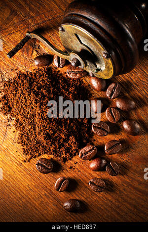 Frisch gemahlener Kaffee mit Handschleifmaschine auf hölzernen Hintergrund. Stockfoto