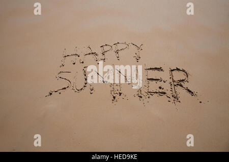 glückliche Sommer geschriebene Text auf braune Sandboden am Strand Stockfoto