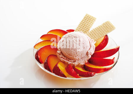 Vanilleeis mit Pflaumenscheiben und Wafer Stockfoto