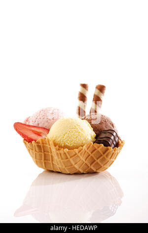 Erdbeere, Vanille und Schokoladeneis, Praline und Wafer rolls in einer Wafer-Schüssel Stockfoto