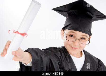 7-jähriger Junge verkleidet als ein Absolvent, Mütze und Mantel, mit Diplom Stockfoto