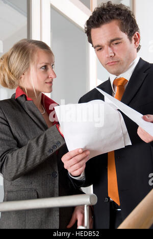 Zwei junge Unternehmer mit Blick auf und diskutieren Dokumente Stockfoto