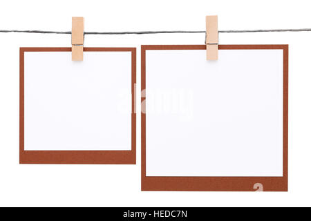 Leere Sofortbild hing am Seil mit Wäscheklammer isoliert auf weißem Hintergrund Stockfoto