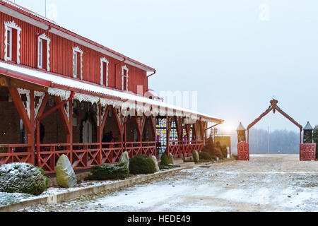 Litauische Landschaft, schneereiche Winter. Baltischen Volksarchitektur mit Holzhäusern, angelegten Park und Restaurant traditionelle litauische Küche Stockfoto