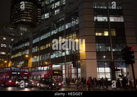 Architektur und Pendler während der Rush Hour in der City of London bei Nacht, England, Vereinigtes Königreich. Stockfoto