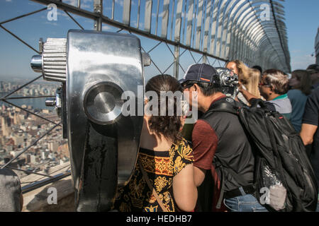 Touristen genießen die spektakuläre Aussicht von der großen Aussichtsplattform des Empire State Building. Stockfoto