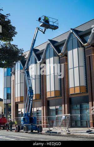 Arbeiten in der Höhe: Männer, die auf einer erhöhten Plattform der Hubarbeitsbühne außerhalb eines neuen Marks and Spencer retail Store, Aberystwyth Wales UK Stockfoto