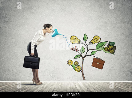 Junge Geschäftsfrau in leeren Raum Gießen gezeichnete Wachstumskonzept mit can Stockfoto