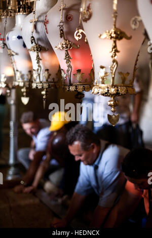 Jerusalem, Israel - 7. November 2013: Lampen und Pilger an den Stein der Salbung in der Kirche des Heiligen Grabes in Jerusalem. Stockfoto