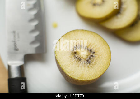 golden Kiwi auf einem weißen Teller geschnitten Stockfoto
