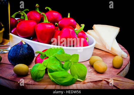 Zutaten für eine mediterrane Sauce für Pasta, Bruschetta, Salat oder Sandwich mit Olivenöl, Paprika, Basilikum, Käse, Feigen und Oliven, ideal für eine fr Stockfoto