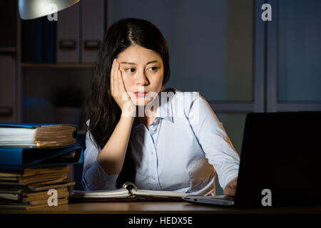 Asien-Geschäftsfrau sitzen am Schreibtisch schläfrig Überstunden spät in die Nacht. im Innenbereich Office-Hintergrund Stockfoto