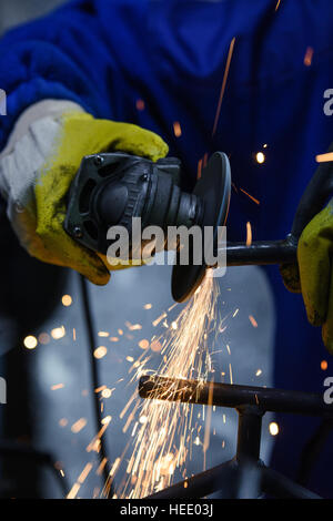 Schneiden von Metall mit Winkelschleifer. Funken beim Schleifen Rohr Stockfoto