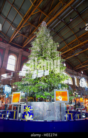 Traditioneller Weihnachtsmarkt im Hauptbahnhof Zürich mit berühmten Swarovski-Weihnachtsbaum im Hintergrund Stockfoto