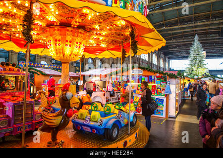 Traditioneller Weihnachtsmarkt im Hauptbahnhof Zürich mit berühmten Swarovski-Weihnachtsbaum im Hintergrund Stockfoto