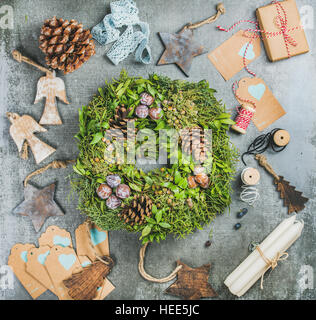 Weihnachtskranz grüne, Tannenzapfen, Holzspielzeug, Kerzen, dekorative Materialien Stockfoto