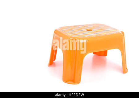 Orange traditionelle Mini vier Beine Plastikstuhl isoliert auf weißem Hintergrund Stockfoto