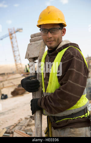 Bauarbeiter in gelben Westen und Handschuhen, die schwere Holzbrettertafel  zusammen tragen, lachen Stockfotografie - Alamy