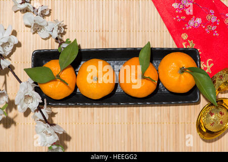 Mandarinen und Lunar New Year mit Text "Frohes neues Jahr" auf rote Tasche. Tet Ferienkonzept. Stockfoto