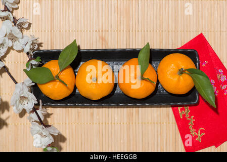 Mandarinen und Lunar New Year mit Text "Frohes neues Jahr" auf rote Tasche. Tet Ferienkonzept. Stockfoto