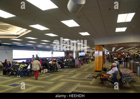 Passagiere warten auf ihren Flügen innerhalb des Terminals am Flughafen von Miami, Florida, USA Stockfoto