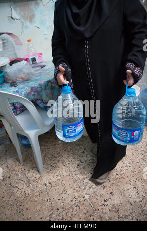 Familien-Kampf, Trinkwasser in die Stadt Zarqa, Jordanien zu rationieren. Stockfoto