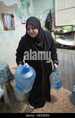 Familien-Kampf, Trinkwasser in die Stadt Zarqa, Jordanien zu rationieren. Stockfoto