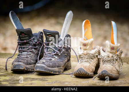 Zwei sodden einweichen nasse gesättigten paar Wanderstiefel austrocknen. Seine und hers. Stockfoto