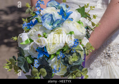 Blau und weiß gehaltenen Braut gegen traditionelle weiße Brautstrauß jeweled Brautkleid mit Perlen Stockfoto