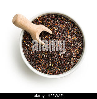 Schwarze Quinoa Samen in Schüssel mit hölzernen Schaufel isoliert auf weißem Hintergrund. Ansicht von oben. Stockfoto