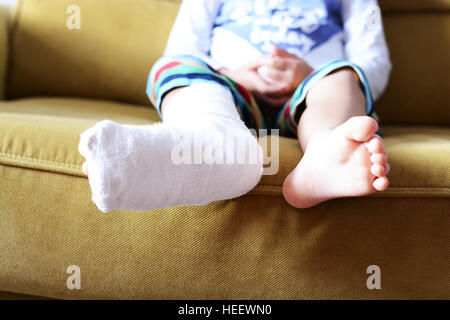 Kleines Kind mit Gips Bandage am Bein Ferse gebrochen Stockfoto