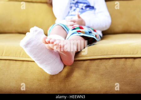 Kleines Kind mit Gips Bandage am Bein Ferse gebrochen Stockfoto