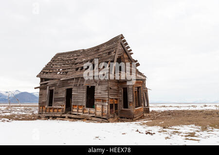 Alten verlassenen Bauernhaus im Winter mit Schnee. Stockfoto