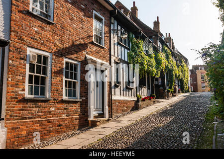 Historische alte englische Stadt Rye. Terrasse von Backstein- und Fachwerkhäuser entlang der gepflasterten Gasse. Zurück beleuchtet. am frühen Morgen. Stockfoto