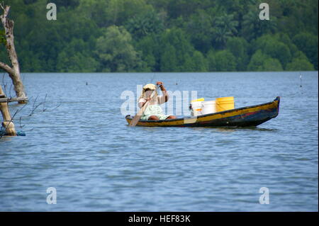 Frau trägt ein frachtboot. Fischerdorf auf dem Wasser. Mengkabong Fluss, Kota Kinabalu, Sabah, Borneo, Malaysia. 22 Jun 2012 Stockfoto