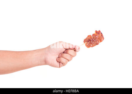 Hand mit gegrilltem Schweinefleisch in Bambusstock isoliert auf weißem Hintergrund Stockfoto