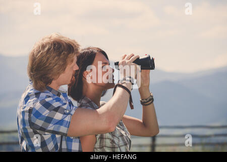 Junges Paar von Reisende, die sich durch ein Fernglas Stockfoto