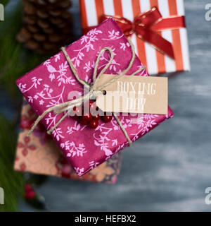 High-Angle Shot von einigen gemütlichen Geschenken in verschiedene schöne Papiere gewickelt und gebunden mit Bändern und Strings in verschiedenen Farben, mit einem Papier-Tag gebunden auf Stockfoto