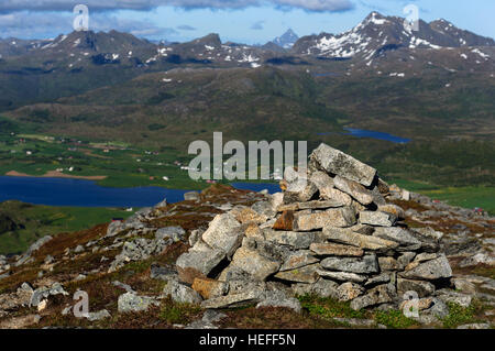 Stapel von Steinen auf Bergspitze in Lofoten, Norwegen. Berge im Hintergrund Stockfoto